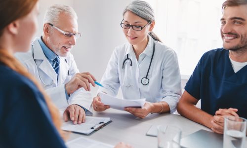 Senior male doctor briefing hospital staff during meeting in hospital